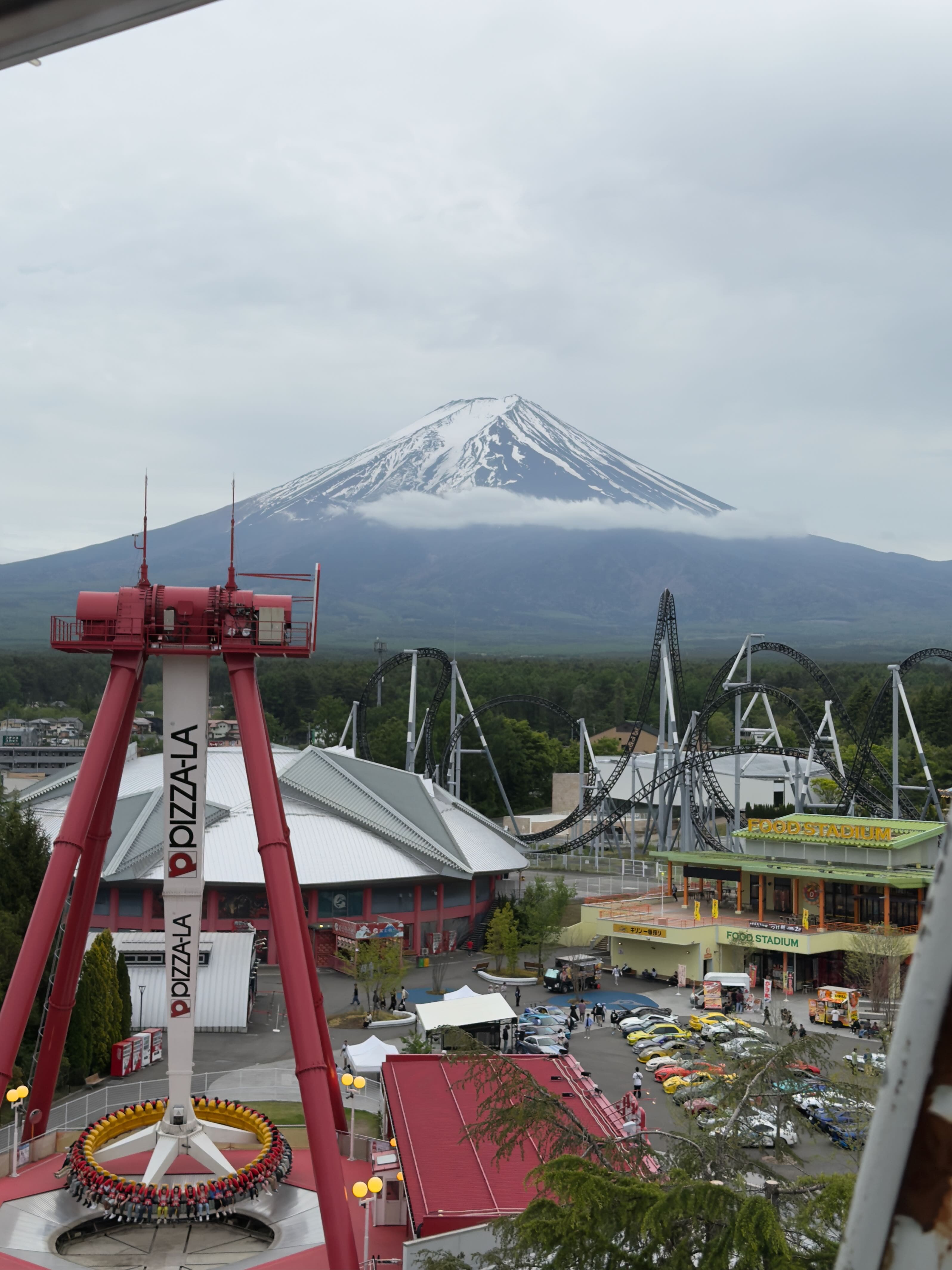 View from inside Fuji-Q Highland with visitors and coaster tracks against a clear blue sky, Japan