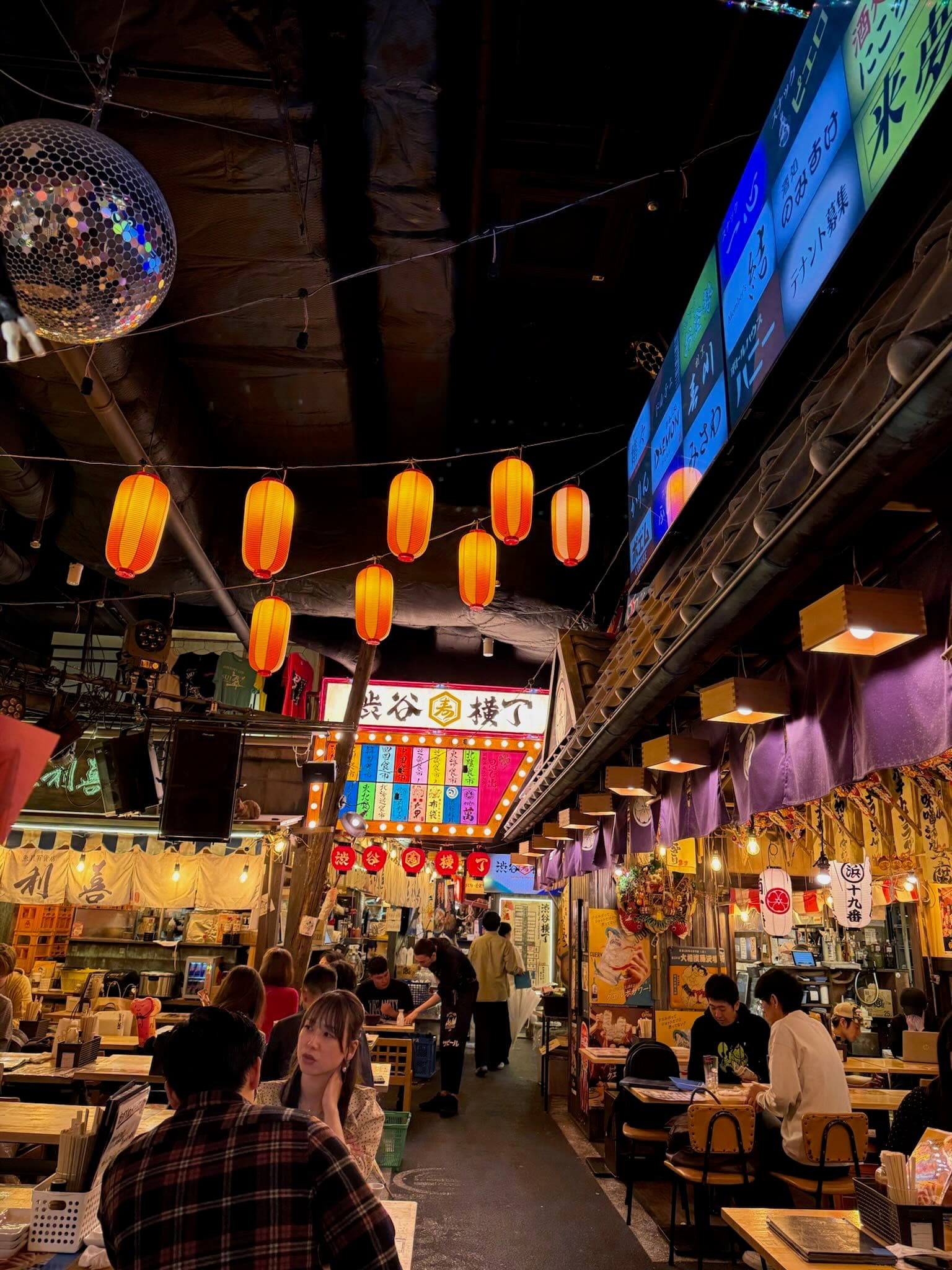 Warm-lit izakaya interior with wooden counters, small plates and sake flasks, Tokyo Japan