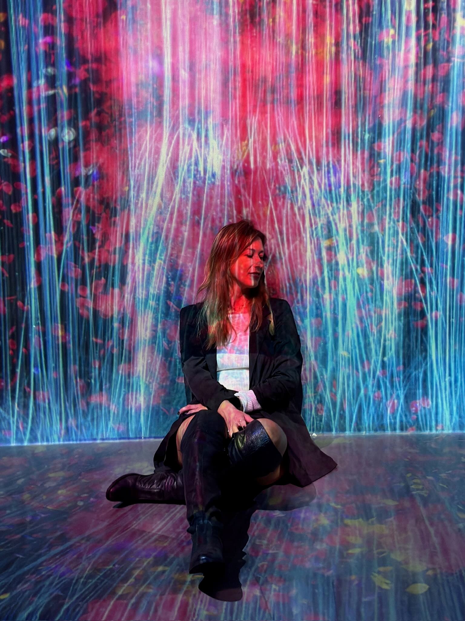 Glowing digital art installation with flowing colours and hanging lanterns at TeamLab Borderless Tokyo